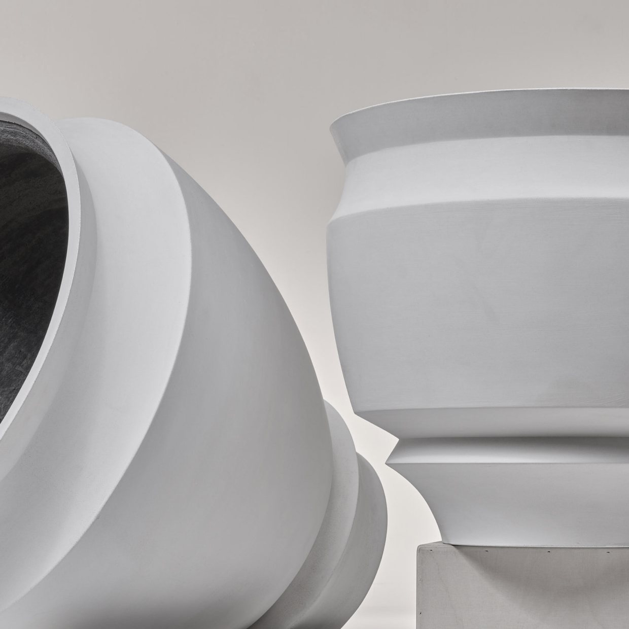 Sirak vessels displayed against a plain wall