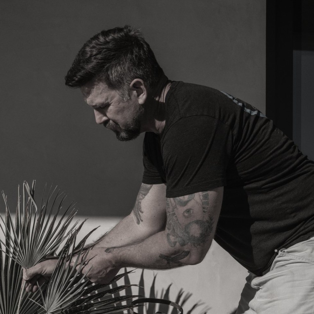 Adam Sirak arranging palm fronds in a vessel