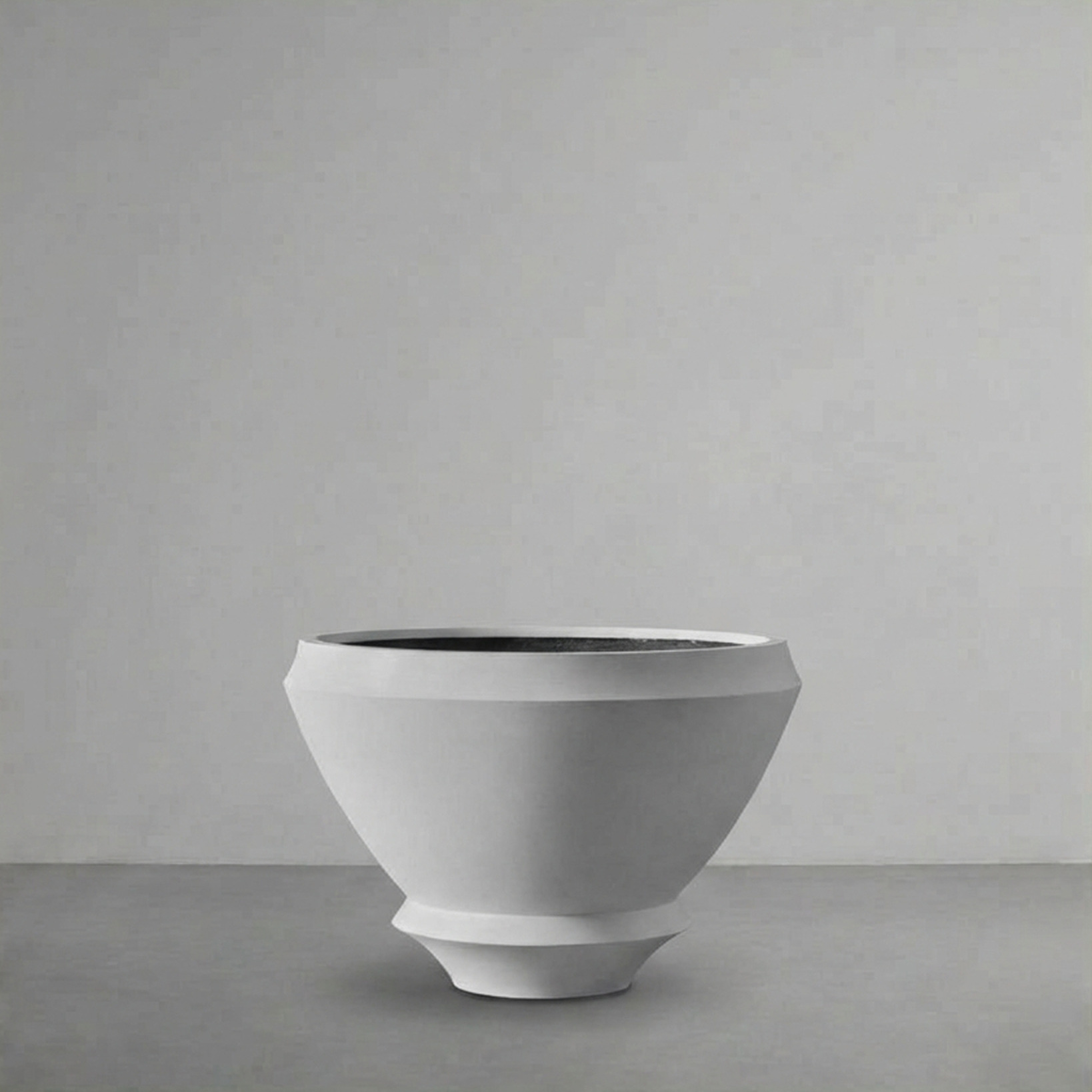Artifact 01 in Alabaster, a wide footed bowl, on a grey studio backdrop