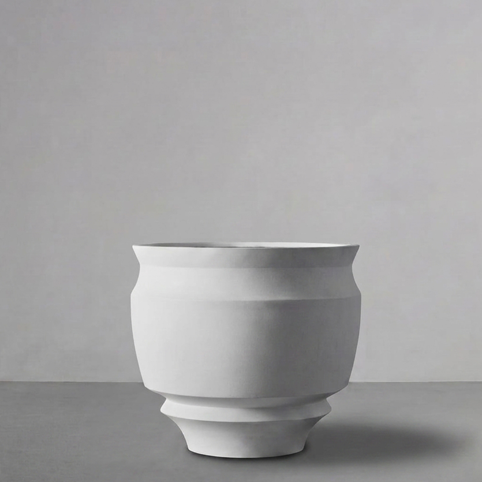 Artifact 02 in Alabaster, a stepped urn, on a grey studio backdrop