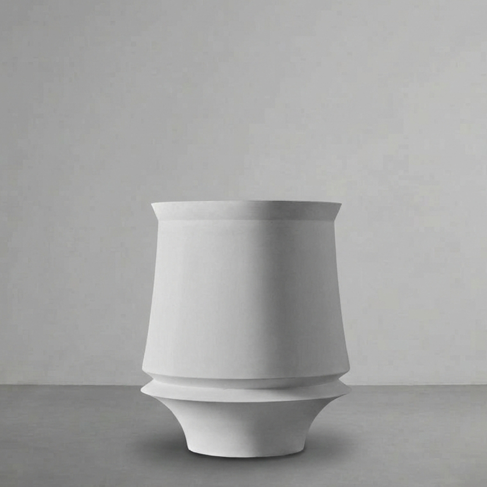 Artifact 03 in Alabaster, a tapered planter on a flared foot, on a grey studio backdrop