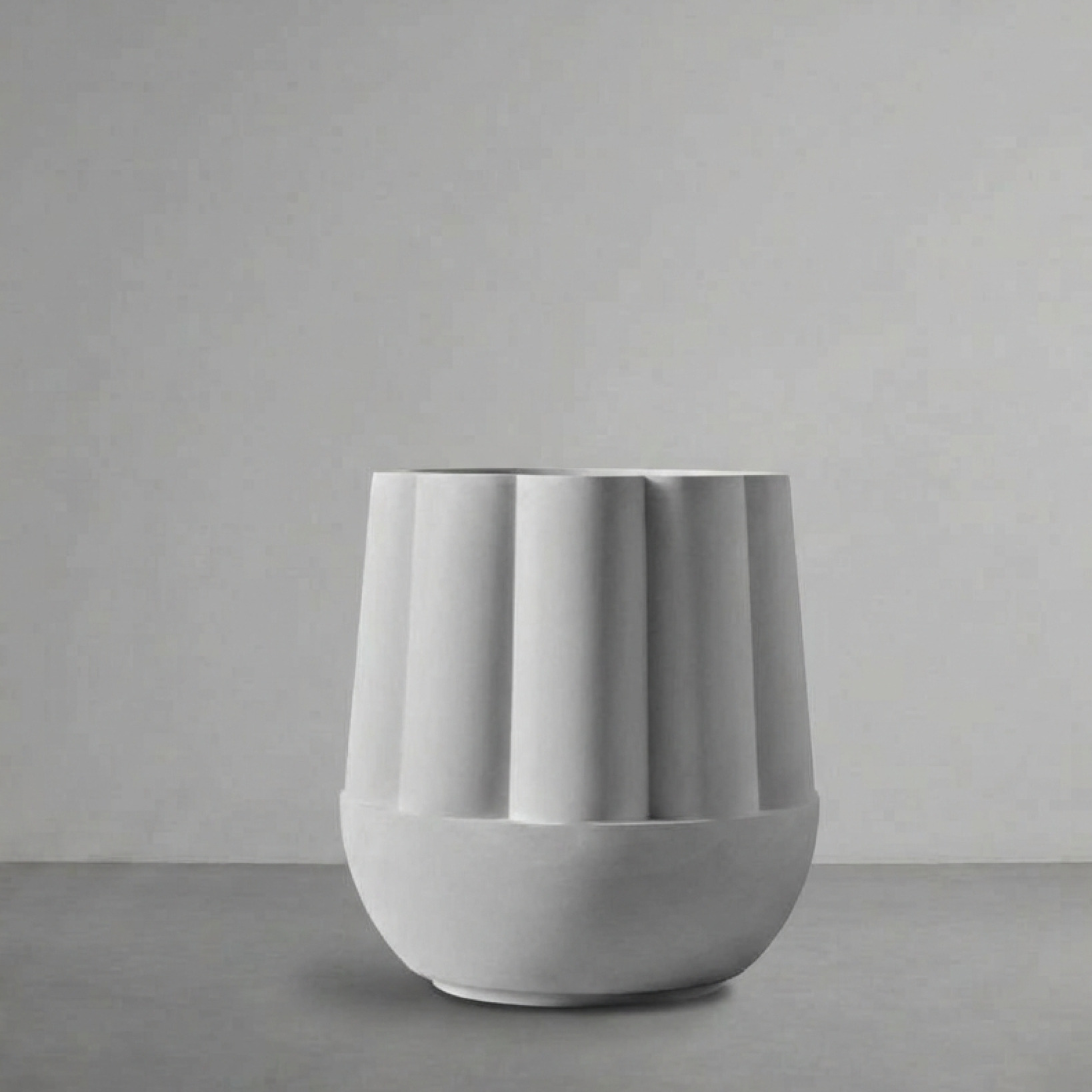 Byblos 01, a fluted rounded planter, on a grey studio backdrop