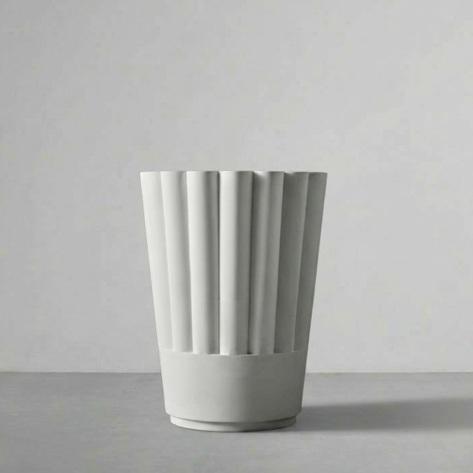 Byblos 02, a flared fluted planter, on a grey studio backdrop