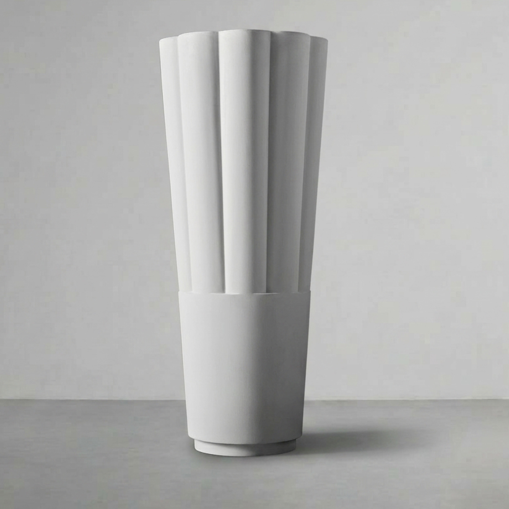 Byblos 03, a tall fluted column, on a grey studio backdrop