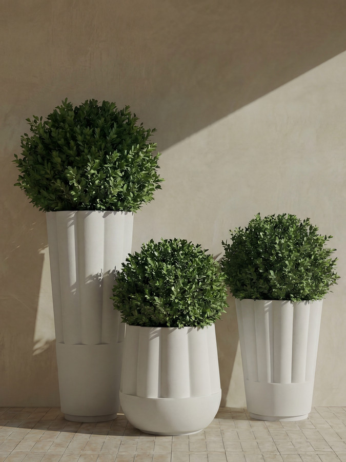 Three Byblos planters of stepped heights holding clipped boxwood spheres