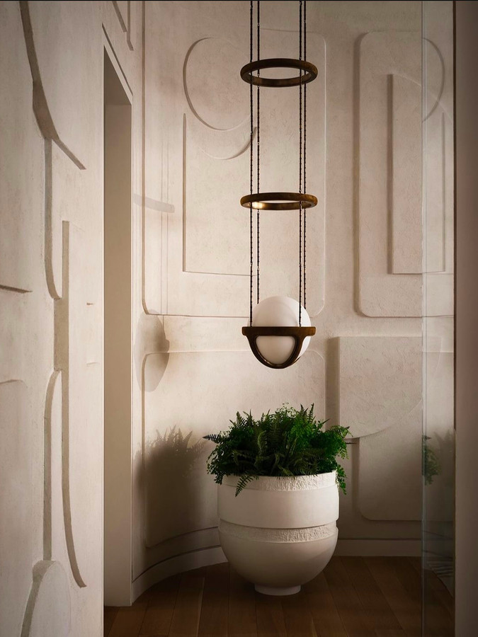 An Orion bowl of ferns in a room with a carved plaster wall