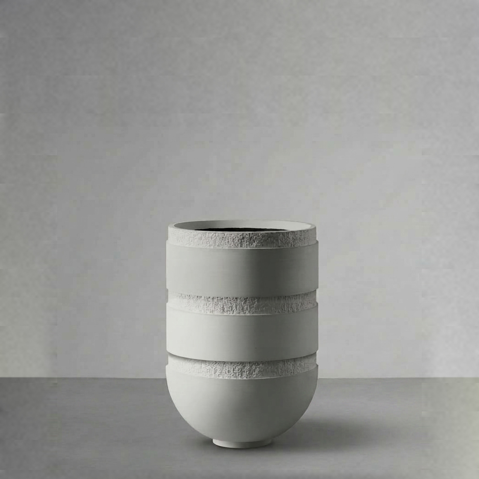 Orion III, a tall banded vessel, on a grey studio backdrop